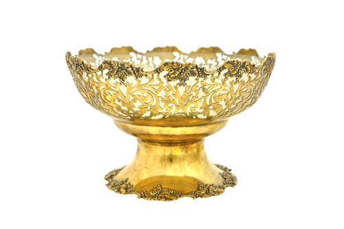 A silver gilt fruit basket, with pierced foliate and scrolling decoration, within a shaped rim cast with fruiting vine and on a similarly decorated sh