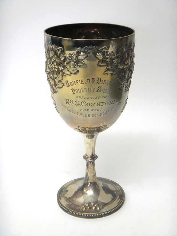 A silver trophy cup, embossed with fruiting vine, raised on a circular foot, decorated with a beaded rim, presentation inscribed, Sheffield 1906, heig