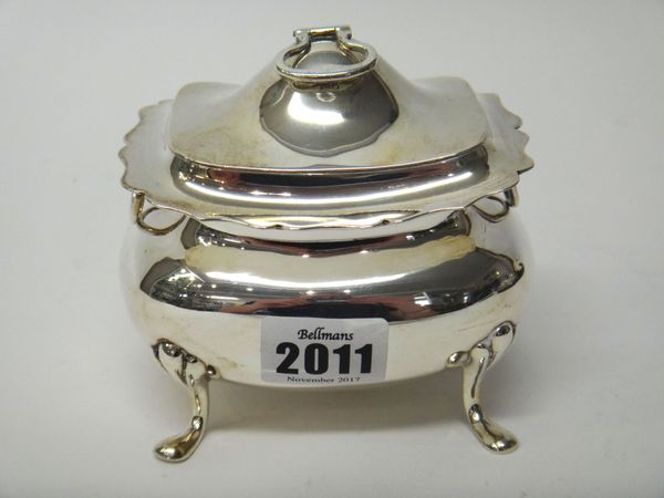 A silver twin handled hinge-lidded tea caddy, of bombe form, raised on four feet, the hinged lid with a loop shaped handle, London 1903, weight 258 gm