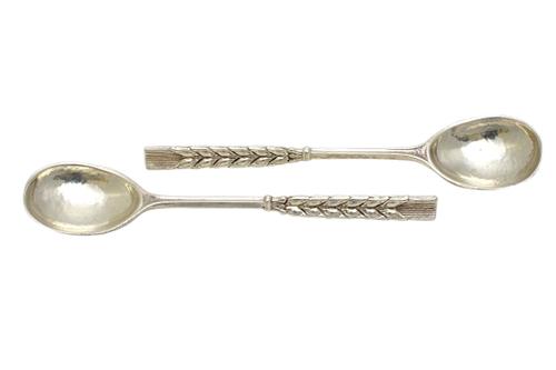A pair of Omar Ramsden silver spoons, each with the handle cast as an ear of corn and with a fig shaped bowl, with foliate decoration to the back, len