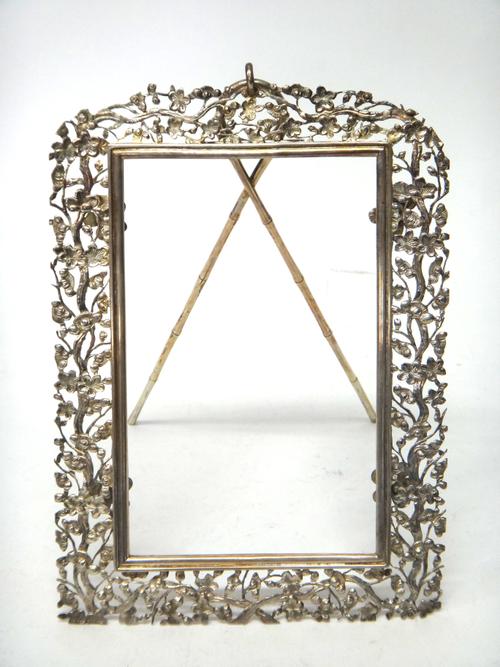 A Chinese shaped rectangular strut backed photograph frame, the surround cast and pierced with blossom, the strut formed as simulated bamboo, the top