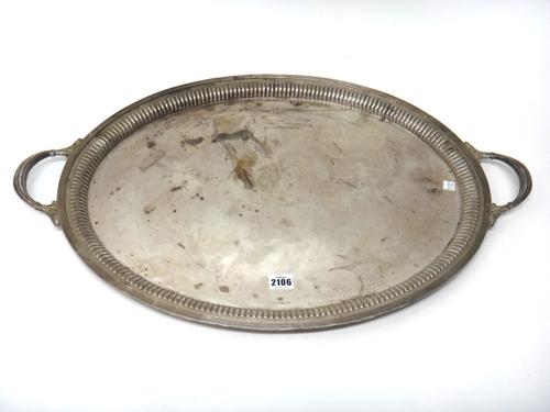 A silver twin handled large oval tray, decorated with a curved fluted border within a reeded rim and with fluted handles ending as scrolled motifs, mo