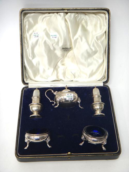 A silver five piece condiment set, comprising; a mustard pot, a pair of salts, having blue glass liners and a pair of pepperettes, London 1927, with a