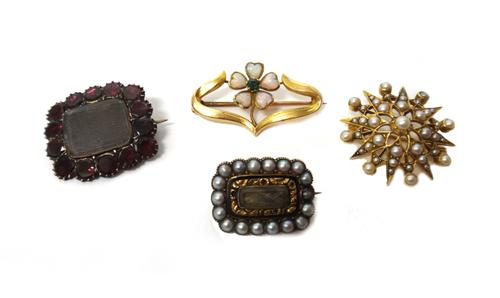 A gold and seed pearl set brooch, designed as a starburst, a shaped rectangular mourning brooch, glazed with a hair locket compartment at the centre a