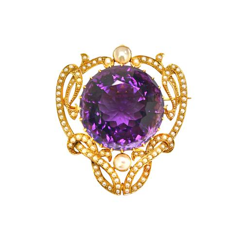A gold, amethyst and seed pearl pendant brooch, in a scroll pierced openwork design, in the Art Nouveau taste, claw set with the large circular amethy