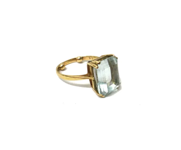 A 9ct gold and aquamarine single stone ring, claw set with a cut cornered rectangular step cut aquamarine, (note arthritic bobbles within the shank),