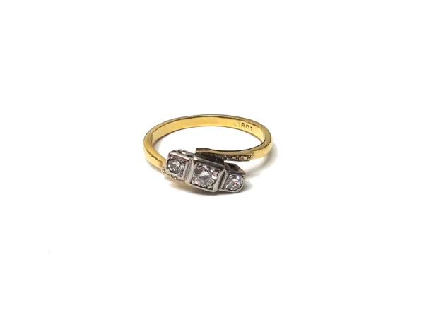 A gold and diamond three stone ring, mounted with a row of circular cut diamonds and with the principle diamond mounted at the centre, in square shape