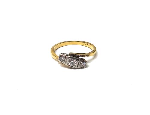A gold and diamond three stone ring, mounted with a row of circular cut diamonds and with the principle diamond mounted at the centre, in square shape