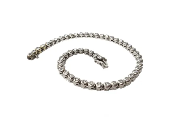 A white gold and diamond bracelet, collet set with a row of circular cut diamonds, on a snap clasp with a foldover safety catch, detailed 14 K, length