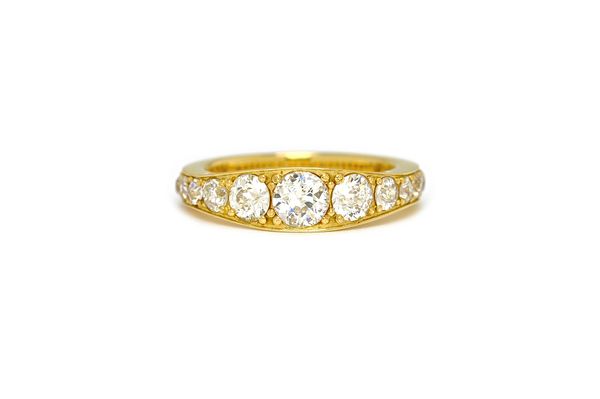 An 18ct gold and diamond ring, mounted with a row of seventeen cushion shaped diamonds graduating in size to the centre stone, ring size P.  Illustrat