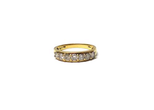 A gold and diamond set seven stone half hoop ring, mounted with a row of circular cut diamonds, ring size O and a half, with a case.
