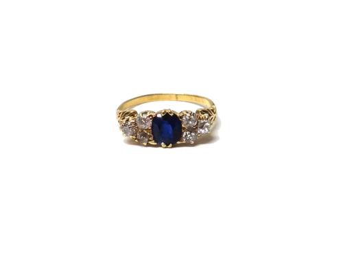A gold, sapphire and diamond ring, mounted with the oval cut sapphire to the centre, between cushion shaped diamond set three stone sides, between scr