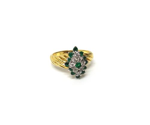 A gold, emerald and diamond set marquise shaped cluster ring, claw set with a circular cut emerald at the centre in a surround of eight circular cut d