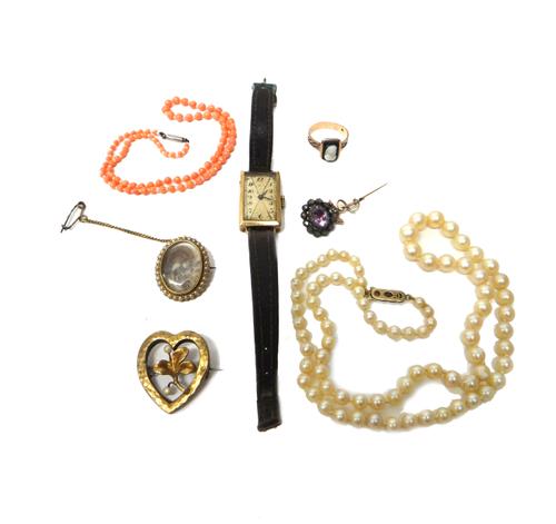 A gold and half pearl set oval brooch, glazed with a woven hair locket compartment, in a surround of seed pearls, a single row necklace of coral beads