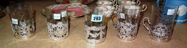 Five German tea glass holders, in a variety of designs, fitted with a variety of glasses and a European shaped circular dish, decorated with a cast fl