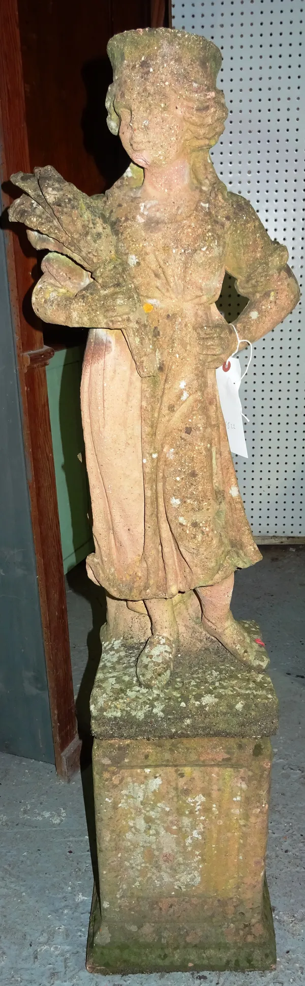A 20th century reconstituted stone figure carrying corn on plinth base, 115cm high. K6