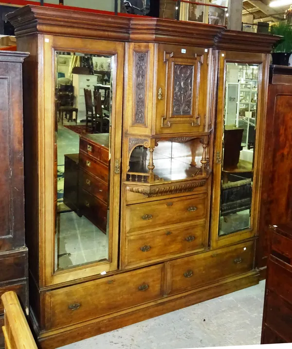 A Edwardian mahogany triple section wardrobe, central section with galleried platform flanked by two mirrored doors over a two drawer base, 198cm wide