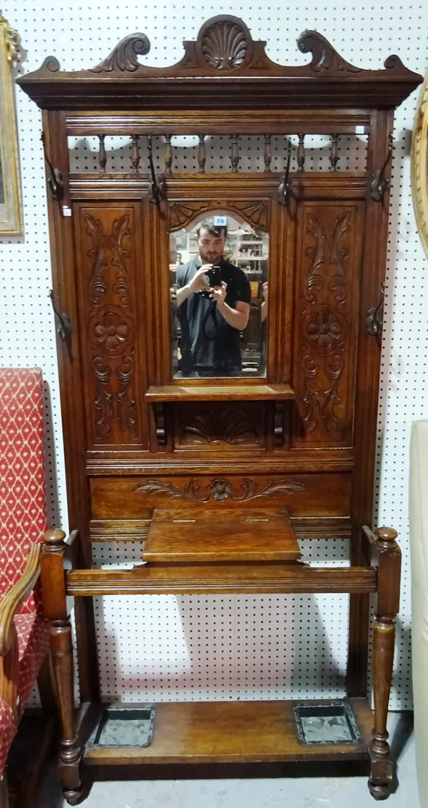 An Edwardian oak hall stand with mirror back, 101cm wide x 193cm high.  I11