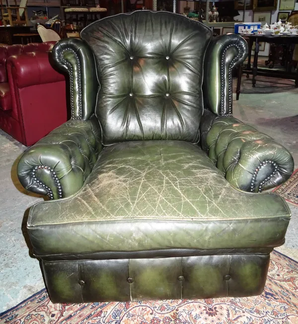 A pair of 20th century wingback armchairs, with green leather upholstery, (2). G4
