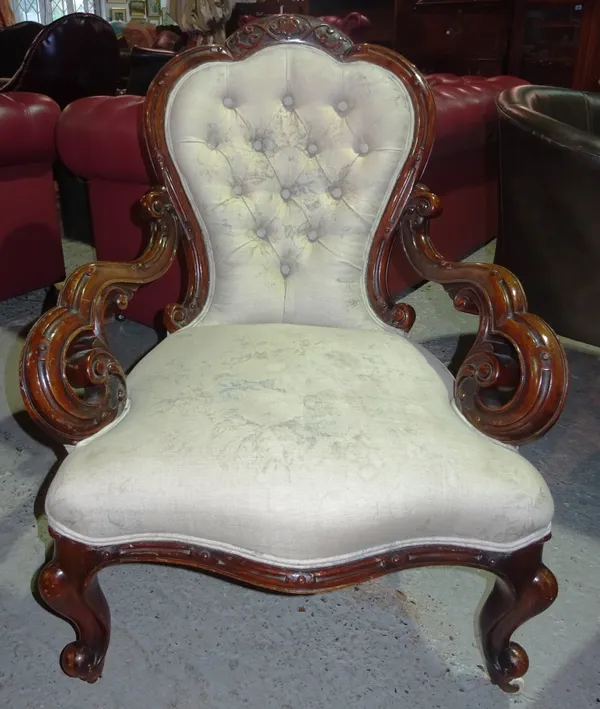 A Victorian walnut balloon back open armchair, on scroll supports. I3