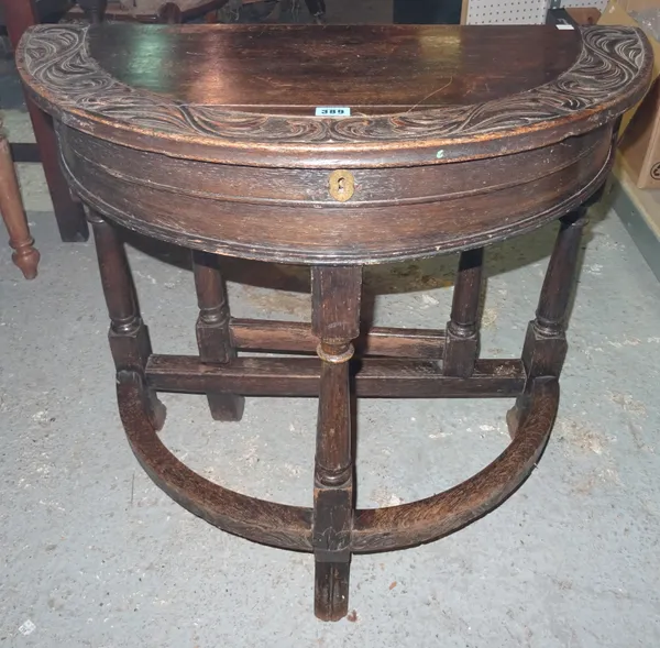 An 18th century and later oak demi-lune side table, on hoof feet, 74cm wide x 70cm high. D3