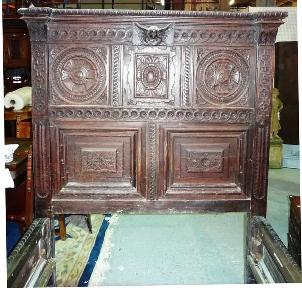 A carved oak bed frame incorporating 17th century and later carvings and elements, with lion head carved posts, 170cm long. K7