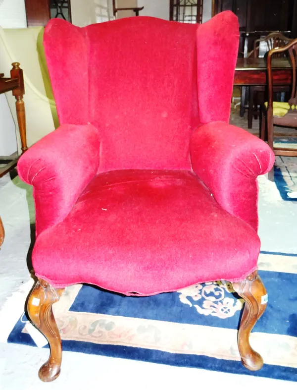A 20th century walnut framed red upholstered wing armchair. J11