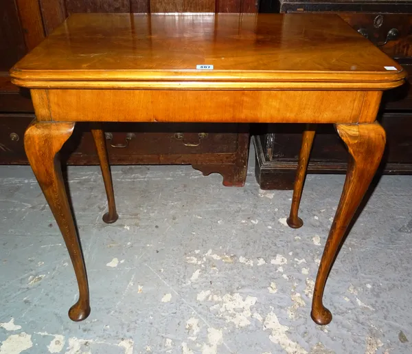 A 20th century walnut fold-over games table, cabriole legs, indistinct maker's stamp to the interior, 76cm wide. K9