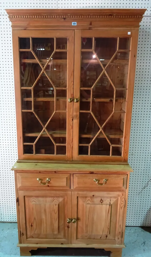 A 20th century pine bookcase cabinet, with astragal glazed doors over cupboard base, 98cm wide. G10
