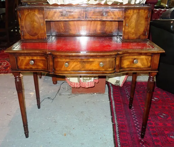 A mahogany lady's writing desk, with two drawers above a recess flanked on each side by a cupboard, the top inset with a tooled and gilt red leather p