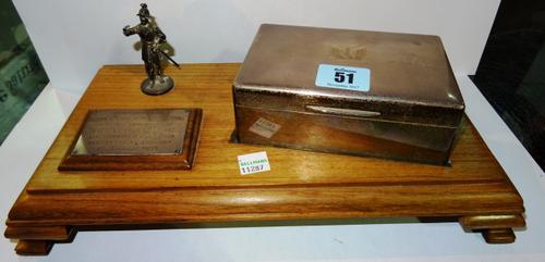 A silver cigarette box, on a display stand. CAB