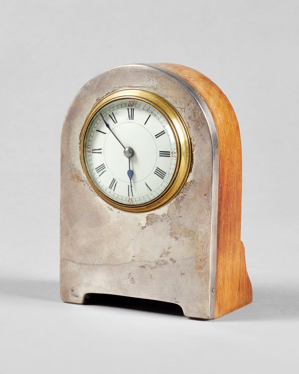 An Edwardian silver and oak timepieceHallmarked Birmingham 1905The arched case above a white enamel dial, with blued steel hands, the movement with re