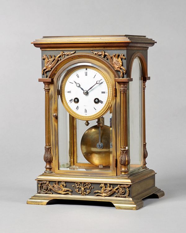 A French gilt brass four-glass mantel clockIn the Empire Revival style, circa 1900, Maple & Co., ParisThe rectangular case with a stepped pediment abo