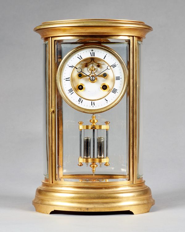 A French ormolu oval four-glass mantel clockCirca 1890The case with a moulded top and inset with shaped bevelled glass panels, the 4¼in. dial with vis