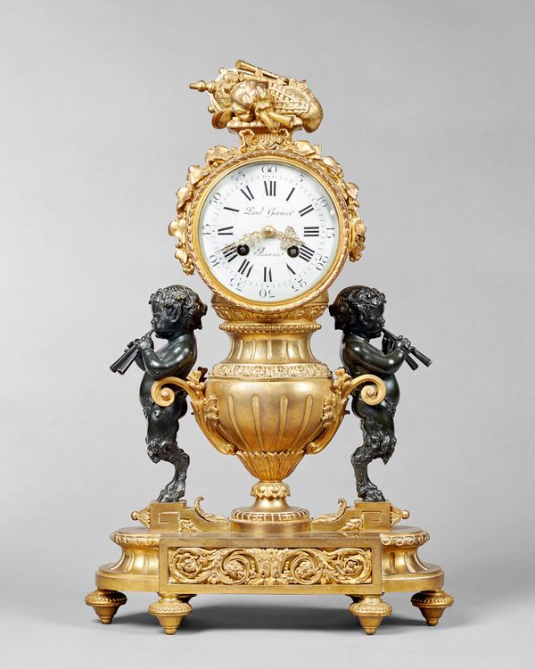 A French ormolu and bronze mantel clockIn the Louis XVI style, circa 1880The case cast as an urn, flanked to each side by a bacchic faun, playing pipe