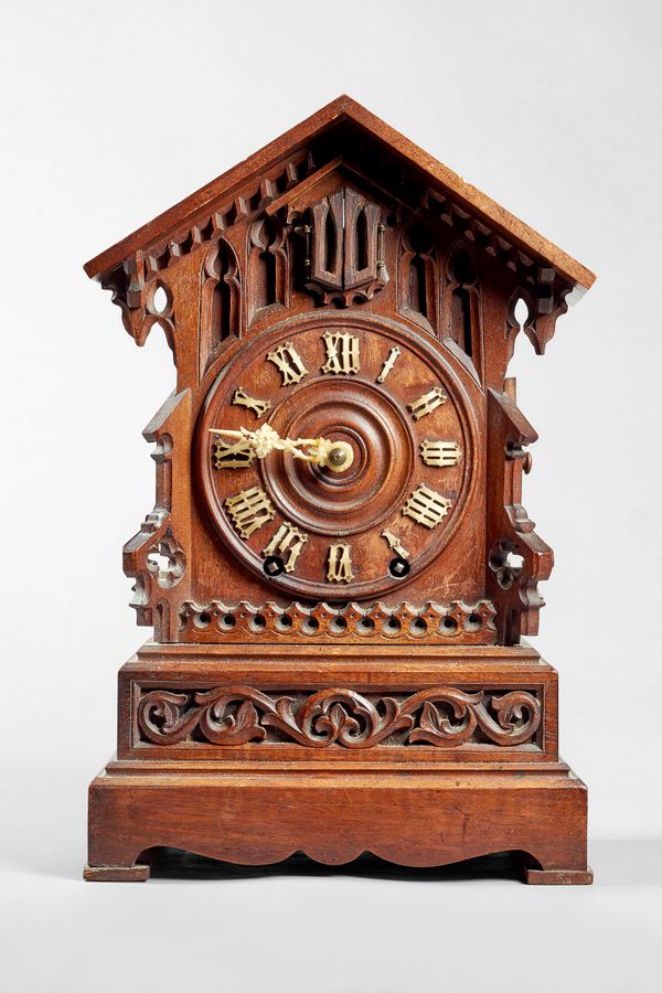 A Tyrolean walnut fusée cuckoo clock Circa 1890The case in the form of a chalet with arched pediment and deep overhang, dentil ornament and blind Goth