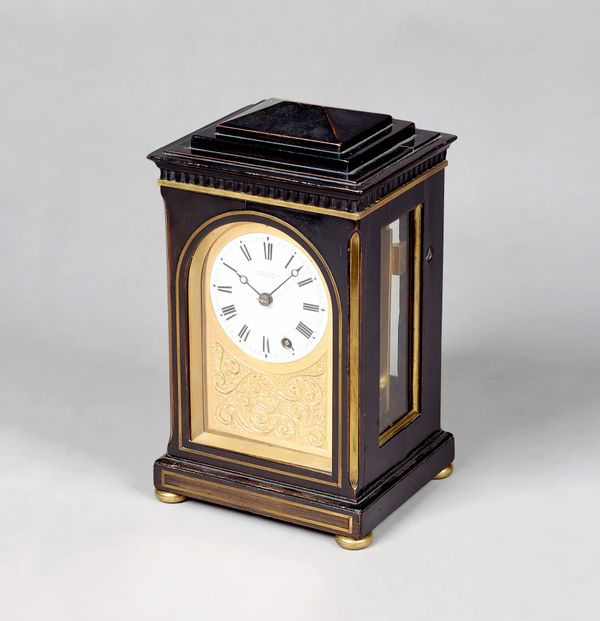 A late Regency brass-mounted ebonised mantel timepieceBy Finer & Nowland, London, circa 1820The chamfer top case with a stepped pediment, above an arc