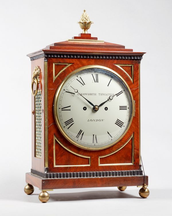 A Regency brass-mounted mahogany bracket clockCirca 1810The chamfer top case surmounted by a pineapple finial, with brass grille panels, on stepped ba