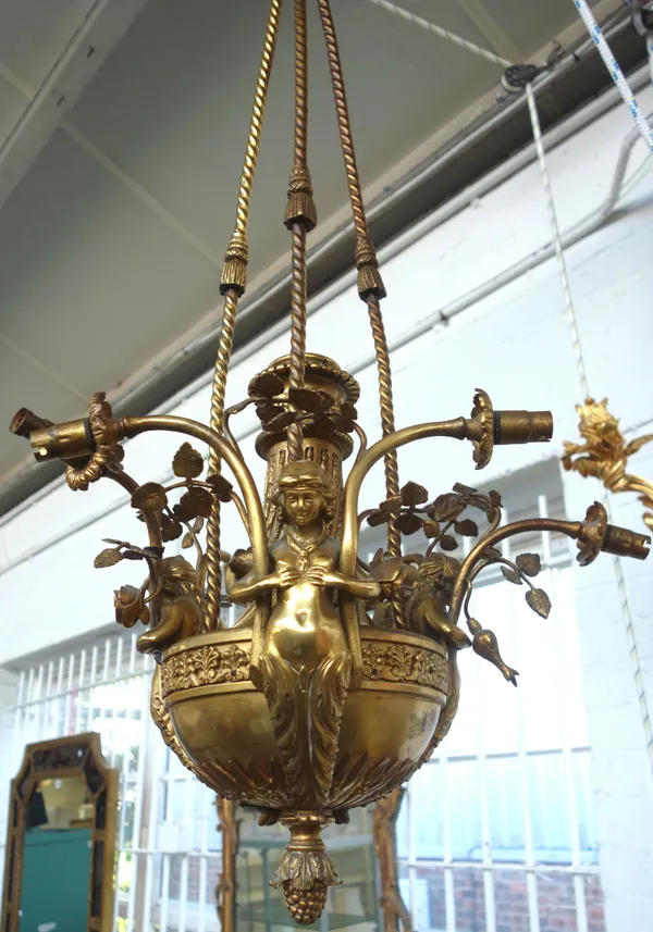 A French gilt bronze six light chandelier, the central urn body issuing three scrolling female figures, each supporting two foliate cast branches susp