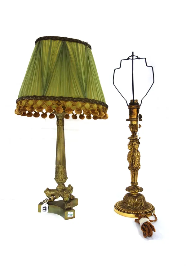 A French ormolu table lamp, 19th century, with a tapering fluted column over three lion paw feet and a triform base, with a pleated green silk shade (