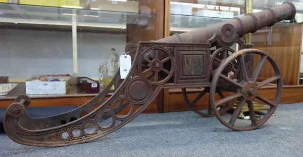 A cast and wrought iron cannon, 20th century, with triple knopped tapering barrel (95cm long), spoked iron wheels and a pierced frame, 158cm wide.