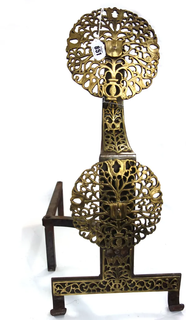 A pair of steel and brass mounted Arts & Crafts andirons, each of foliate pierced form on two shaped feet, 63cm high. (2)