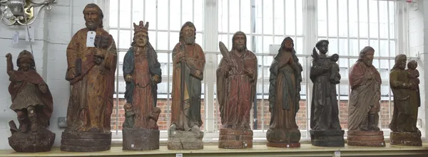 Eight polychrome painted wooden religious figures, early 20th century, each raised on a naturalistic shaped base, and a similar carved wooden figure d