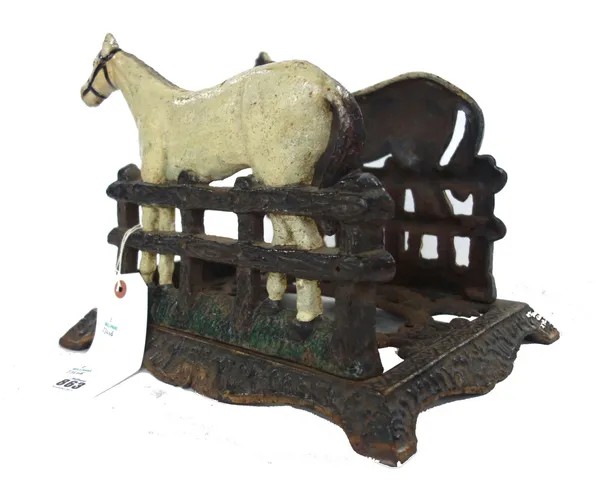 A Victorian cast iron boot scraper, polychrome decorated and cast as opposing horses united by scroll work frame, with central oval brush recess, rais