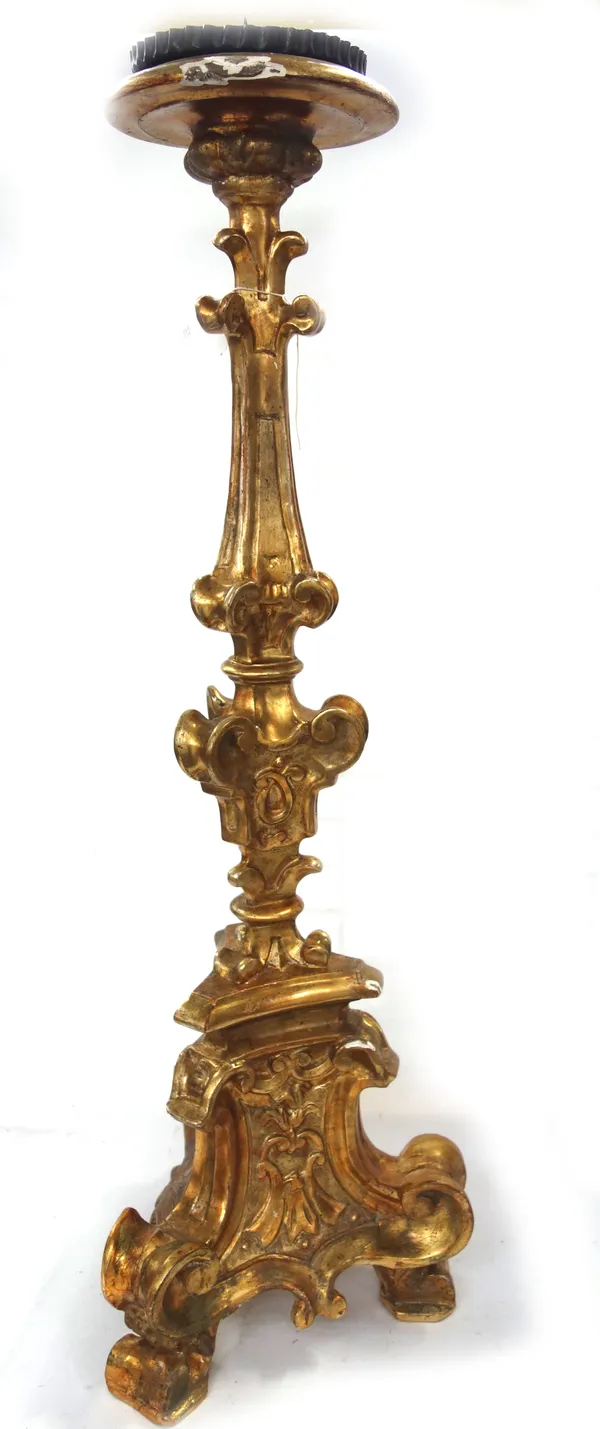 An Italian giltwood carved altar candlestick, 20th century, foliate carved on a triform base, 88cm high.
