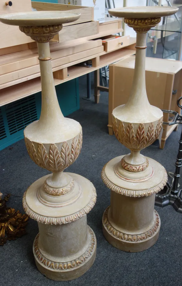 A pair of modern wooden jardinieres, each cream and gilt with carved foliate decoration, over a tapering cylindrical body, 113cm high, (2).