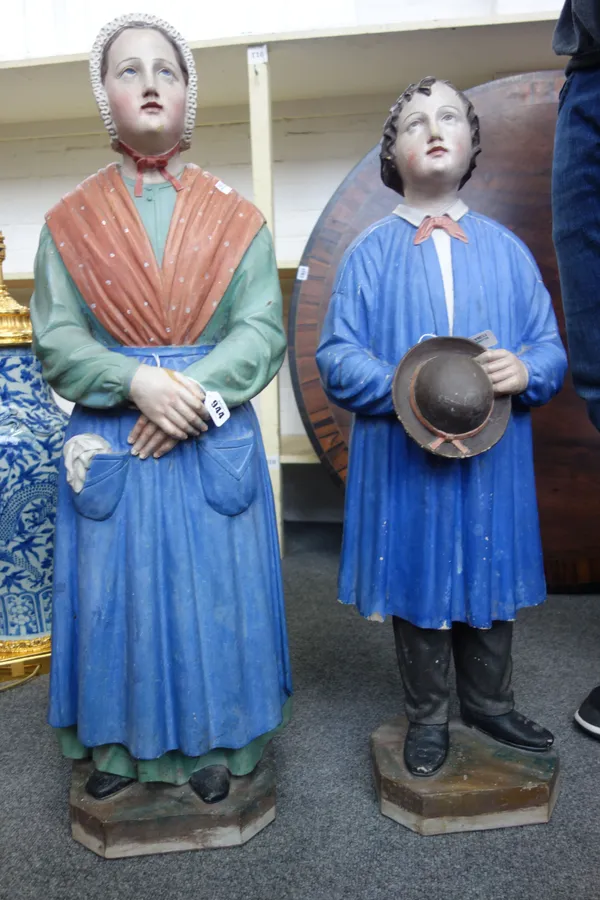 A pair of French polychrome painted terracotta figures, circa 1900, each depicting a penitent peasant on a canted rectangular base, impressed 'Mon Gou