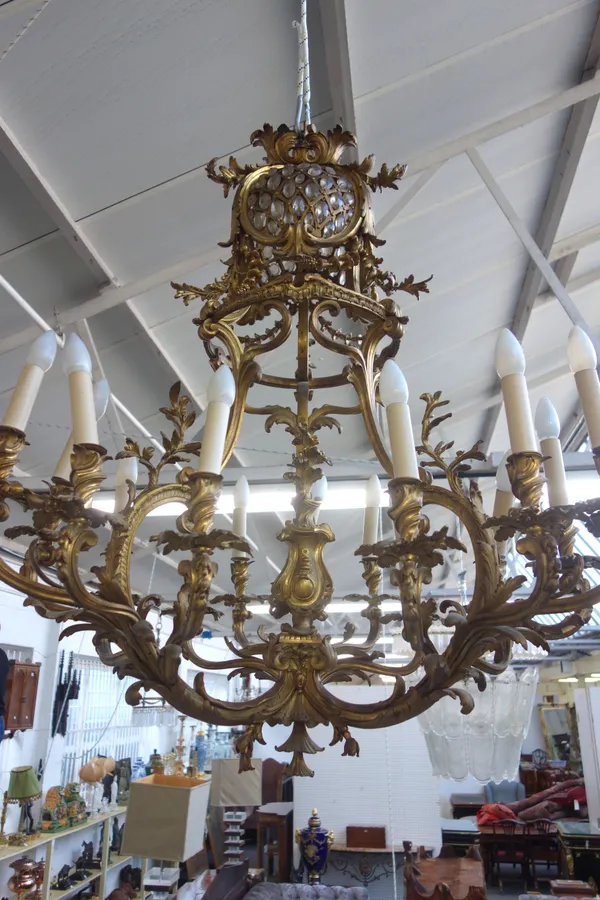 A French gilt bronze fifteen light chandelier, late 19th century, the pierced dome with applied cut glass drops over a circlet united by floral swags,