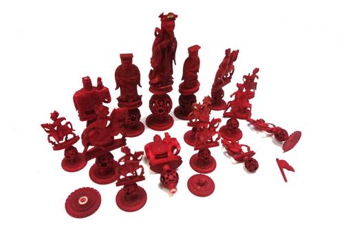 A Chinese export 'Puzzle ball' stained ivory part chess set, early 20th century, each figure carved on a concentric ball and circular lotus pad base,