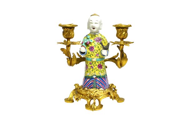 A French ormolu mounted Chinese famille rose porcelain two light candelabra, possibly by Escalier de Cristal, modelled with an Oriental figure flanked